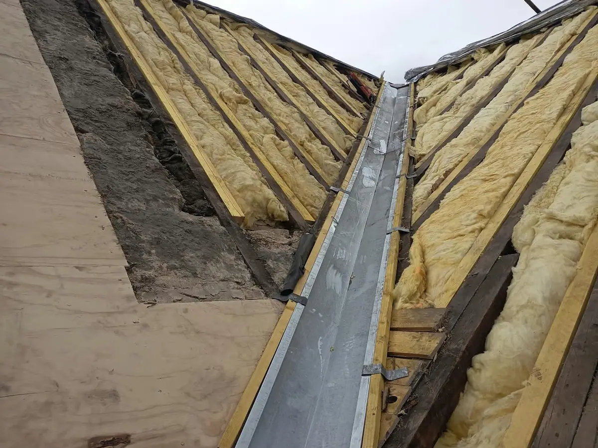 La même noue depuis le même point : noue zinc neuve, bois repris et isolant neuf entre chevrons — ETS Louis Père et Fils